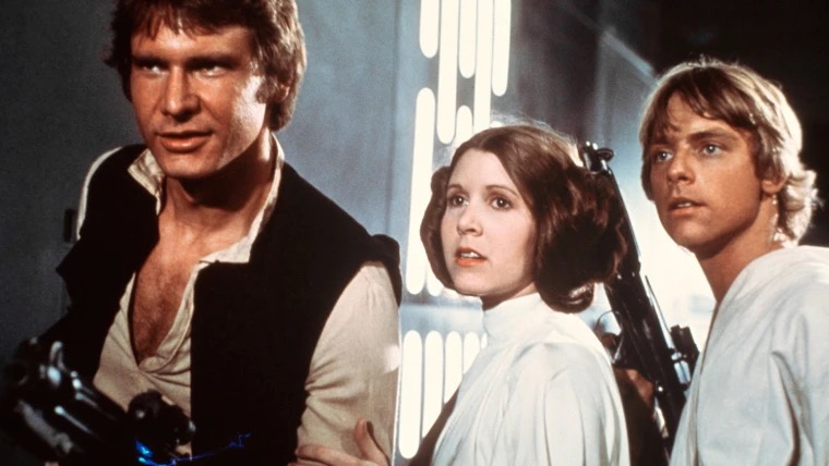 Two men and a woman holding guns, a moment from Star Wars