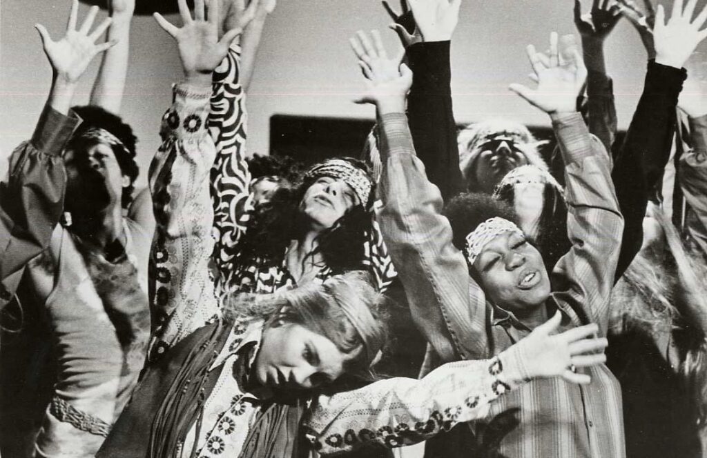 A group of people dancing with their hands up