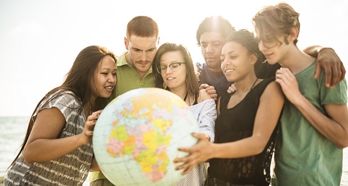 A group of people holding a globe in their hands