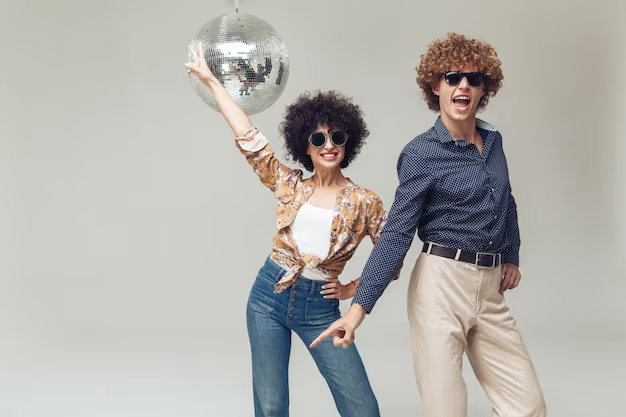 Man and woman in 70s style dancing under a disco ball