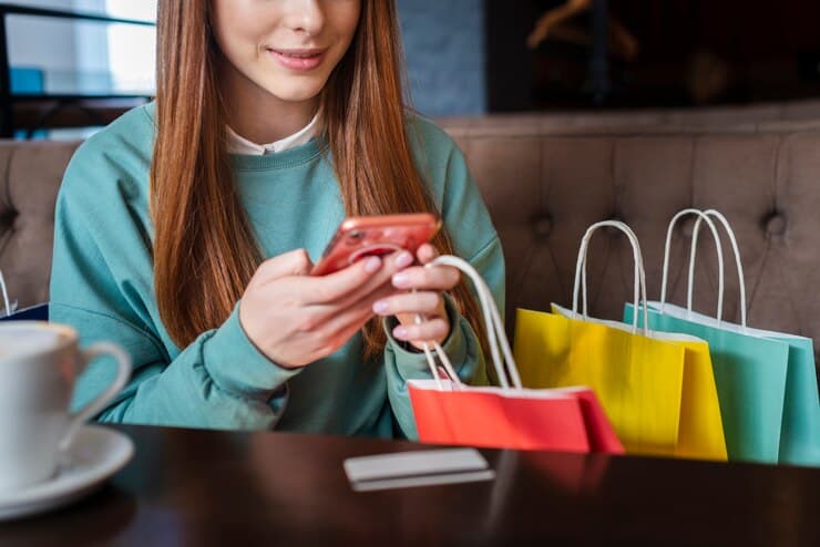 Woman with new Purchases Checking her Phone