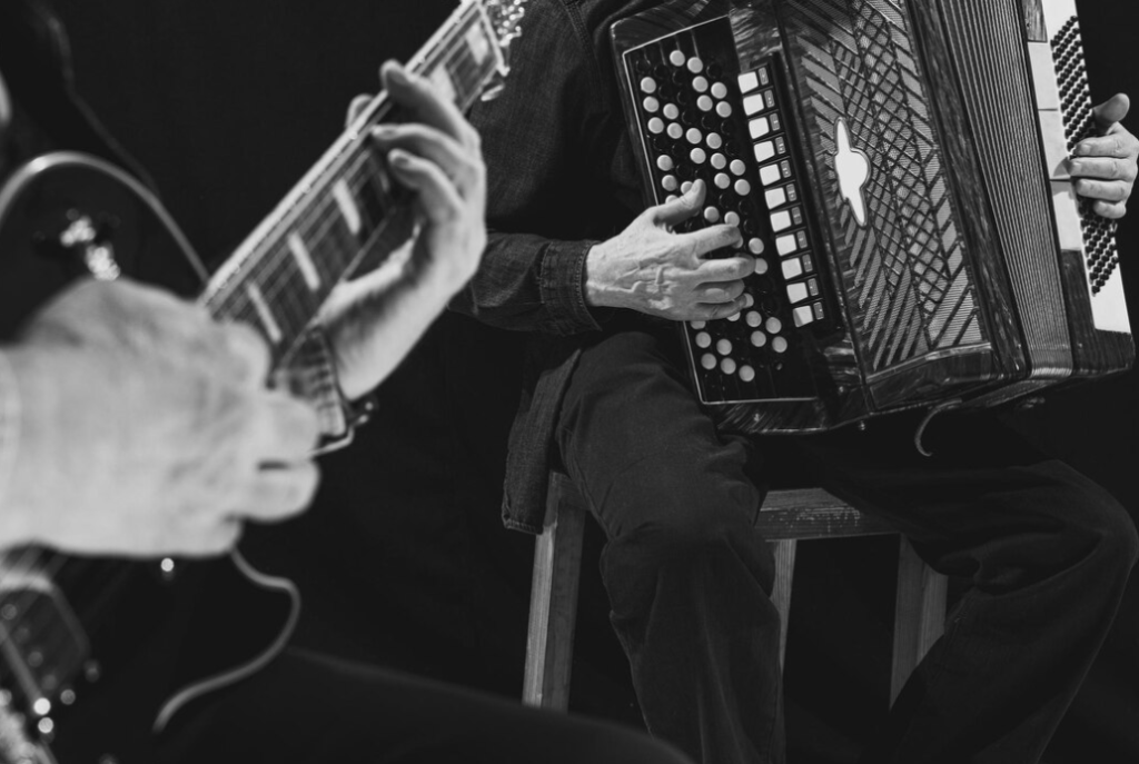 hands skillfully playing a guitar and accordion, highlighting their artistry