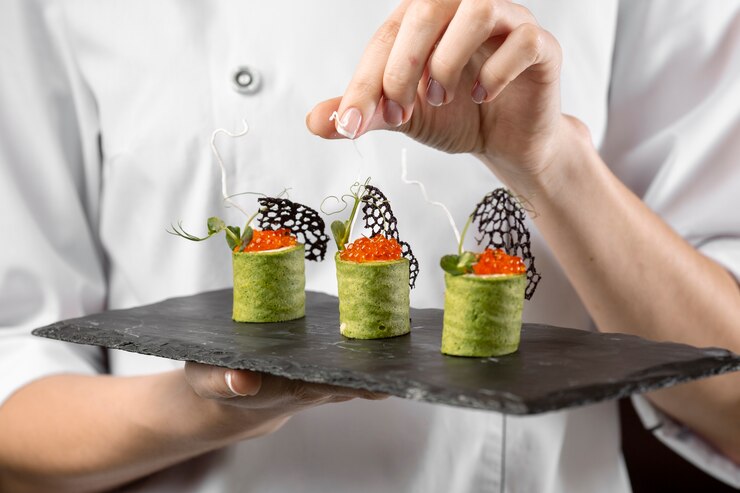 a woman holding a tray with three delicious sushi rolls