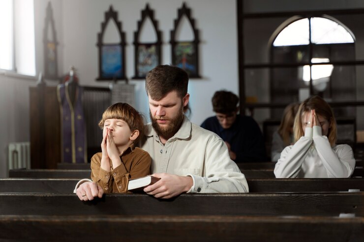 a man and his son praying together in a place of worship