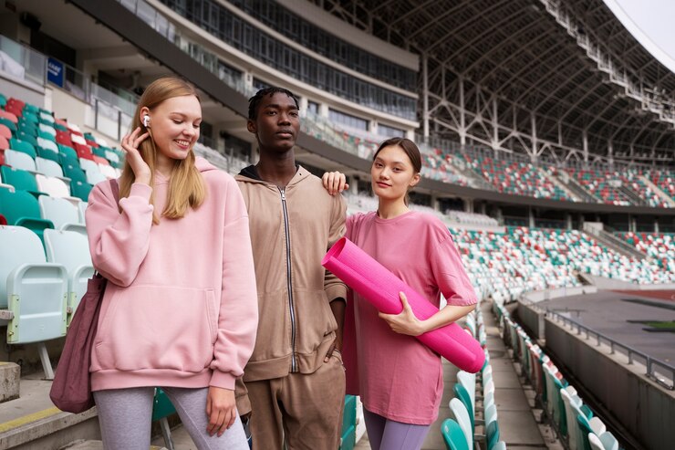 two young women and a man standing at the stadium’s stand